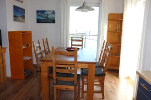 ein Esszimmer mit einem Holztisch und Stühlen in der Unterkunft FLOATING HOUSES - "schwimmende Ferienhäuser" - Haus 3 in Barth