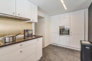 uma cozinha com armários brancos e um lavatório em Sersea - spacious holiday house in Ostend with garage em Oostende