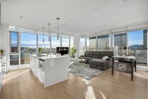 cocina y sala de estar con sofá y mesa en Downtown Luxurious Apartment with Parking and Gym en Calgary