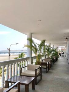 un balcone con panchine, tavoli e spiaggia di Hotel Pakatnamu a Pacasmayo