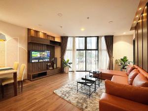 Una sala de estar con un sofá, una mesa y un televisor. en Condo 2 Bedrooms Mountain view in Dalat Center Residence, en Da Lat