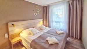 1 dormitorio con 1 cama con 2 almohadas en HOLIDAY HOME Bel Mare 314e en Międzyzdroje