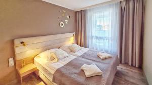 a bedroom with a bed with two pillows on it at HolidayHomePL Bel Mare 314e z sypialnią i balkonem in Międzyzdroje