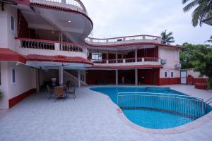 un bâtiment avec une piscine en face d'un bâtiment dans l'établissement Sunshine Resort Calangute Goa, à Calangute