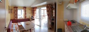 Bretagne-dʼArmagnacCamping les Lacs d'Armagnac的客房设有桌子和带阳台的厨房