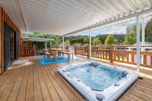 a hot tub on the deck of a house at Tranquil private house w hot tub steps to beach. in Gibsons