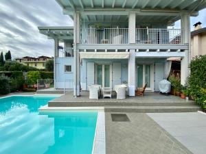 ein Haus mit Pool davor in der Unterkunft Villa Chiara in Polpenazze del Garda