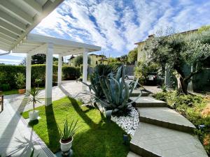 eine Terrasse mit Pflanzen in einem Hof mit einer weißen Pergola in der Unterkunft Villa Chiara in Polpenazze del Garda