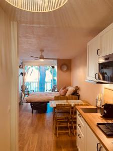 ein Wohnzimmer mit einem Bett und eine Küche in der Unterkunft La bohème Studio in La Grande-Motte