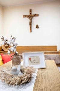 einem Holztisch mit einem Kreuz und einem Laptop darauf in der Unterkunft Ferienwohnungen Dietmar Thöni inclusive Pitztal Sommercard in Arzl im Pitztal