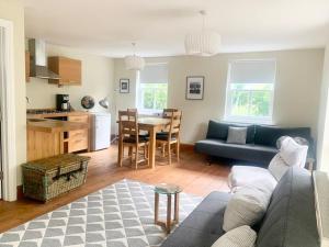 a living room with a couch and a table and a kitchen at Delightful Ely house Bright and warm with cathedral view in Ely