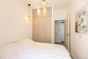 sypialnia z białym łóżkiem i szafą w obiekcie Superbe f1 au cœur du carré d’or terrasse/clim w Nicei