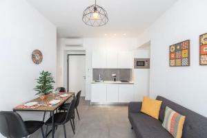 a dining room and kitchen with a table and a couch at Superbe f1 au cœur du carré d’or terrasse/clim in Nice