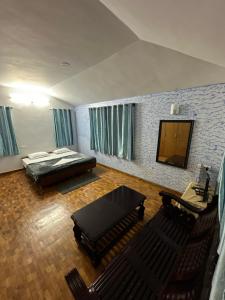 a bedroom with a bed and a table and chairs at Nivi Homestay Ooty By Lexstays in Ooty