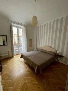 een slaapkamer met een bed en een groot raam bij La Casa di Titilla in Turijn