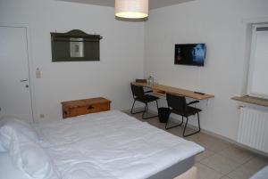 1 dormitorio con cama, escritorio y mesa en B&B Coup de Coeur, en Moorslede