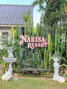 a sign that reads nishiasha resort in front of a garden at เนริสารีสอร์ท เขาค้อ in Ban Khao Ya Nua