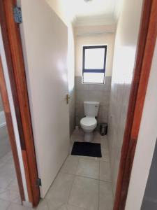 a small bathroom with a toilet and a window at MV self-catering - Rooms in Bloemfontein