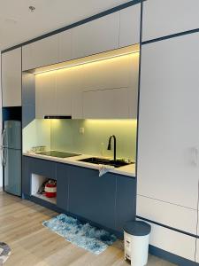 een keuken met witte kasten, een wastafel en een koelkast bij LALA HOMESTAY ECOPARK - 29m² Studio Apartment 