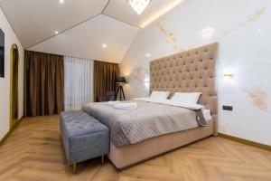 a bedroom with a large bed with a large headboard at MYFREEDOM Premium Apartments near Khreshchatyk in Kyiv
