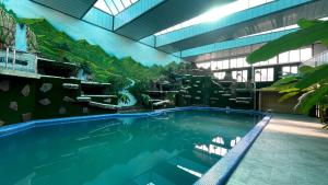 ein großes Schwimmbecken in einem Gebäude mit Wasserfall in der Unterkunft Chinor plus hotel in Rishton