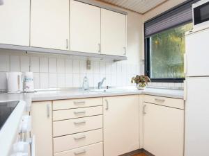 シルケボーにある4 person holiday home in Silkeborgの白いキャビネットとシンク付きのキッチン