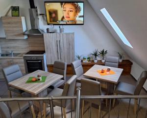 a kitchen with two tables and a tv on the wall at ODRANSKA KLET D.O.O. in Sisak