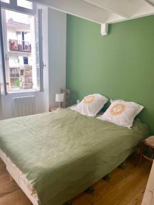 - une chambre avec un lit vert et 2 oreillers dans l'établissement FACE MER La Baule Le Panoramique, à La Baule