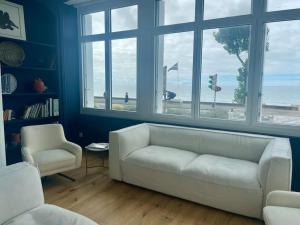 - un salon avec un canapé blanc et deux chaises dans l'établissement FACE MER La Baule Le Panoramique, à La Baule
