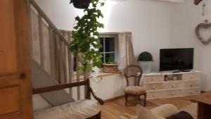 uma sala de estar com uma escada e uma televisão em Le Clos des Lavandes em Ruffey-lès-Beaune