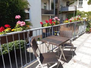 una mesa y sillas en un balcón con flores en Citywohnung im Paulusviertel I, en Halle an der Saale