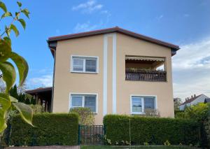 a house with a balcony and bushes at Ferienwohnung „Thea“ in Bad Lausick