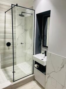 uma casa de banho com um chuveiro e um lavatório. em Pavilion Hotel Durban em Durban