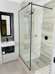 um chuveiro com uma porta de vidro na casa de banho em Pavilion Hotel Durban em Durban