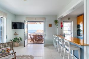 eine Küche und ein Esszimmer mit Meerblick in der Unterkunft Aloha Apartment Arrifana in Arrifana Strand