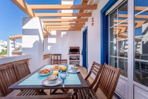 einen Holztisch mit Essen auf dem Balkon in der Unterkunft Aloha Apartment Arrifana in Arrifana Strand
