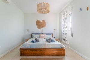 Schlafzimmer mit einem Bett und einem Kronleuchter in der Unterkunft Aloha Apartment Arrifana in Arrifana Strand