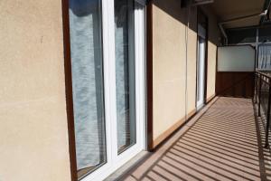 einen leeren Balkon mit Fenstern in einem Gebäude in der Unterkunft Concept Apartment in Belpasso