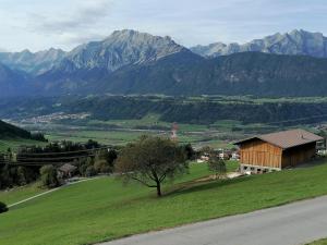 a house on a hill with mountains in the background at Zirlerhof in Weerberg