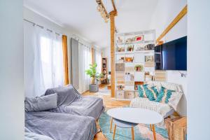ein Wohnzimmer mit einem Sofa und einem Tisch in der Unterkunft Greg & Theo's in Fontenay-sous-Bois