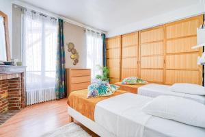 2 camas en una habitación con chimenea en Greg & Theo's, en Fontenay-sous-Bois