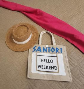 un cappello di paglia e una borsa con un cartello "Hello Weekend" di Santori Villa My Khe Beach a Da Nang