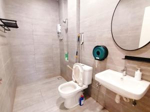 a bathroom with a toilet and a sink and a mirror at The Foreigner Staycation at Riverine Diamond Kuching in Kuching