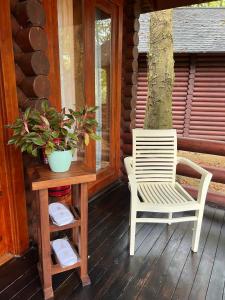 una sedia e un tavolo sul portico di una cabina di Philea Resort & Spa a Malacca