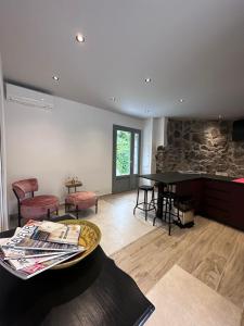 - un salon avec une table et un mur en pierre dans l'établissement Hôtel Domaine A Flatta, à Calenzana