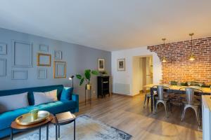 ein Wohnzimmer mit einem blauen Sofa und einer Ziegelwand in der Unterkunft Les Cordeliers: 2 pers, cosy & cœur vieille ville in Annecy