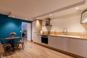 a kitchen with a table and a dining room at Les Cordeliers: 2 pers, cosy & cœur vieille ville in Annecy +6 photos