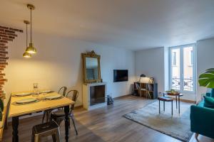 ein Wohnzimmer mit einem Tisch und einem Spiegel in der Unterkunft Les Cordeliers: 2 pers, cosy & cœur vieille ville in Annecy