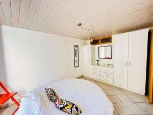 ein Schlafzimmer mit einem Bett und einer weißen Wand in der Unterkunft Apart'Hotel du Faubourg by Stay Swiss in Pruntrut