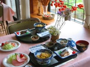een tafel met borden met voedsel op een tafel bij Country Inn Kashiwabara in Hakuba